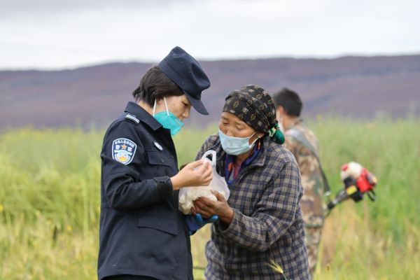 群众拿着自家做的奶疙瘩与移民警察分享.jpg