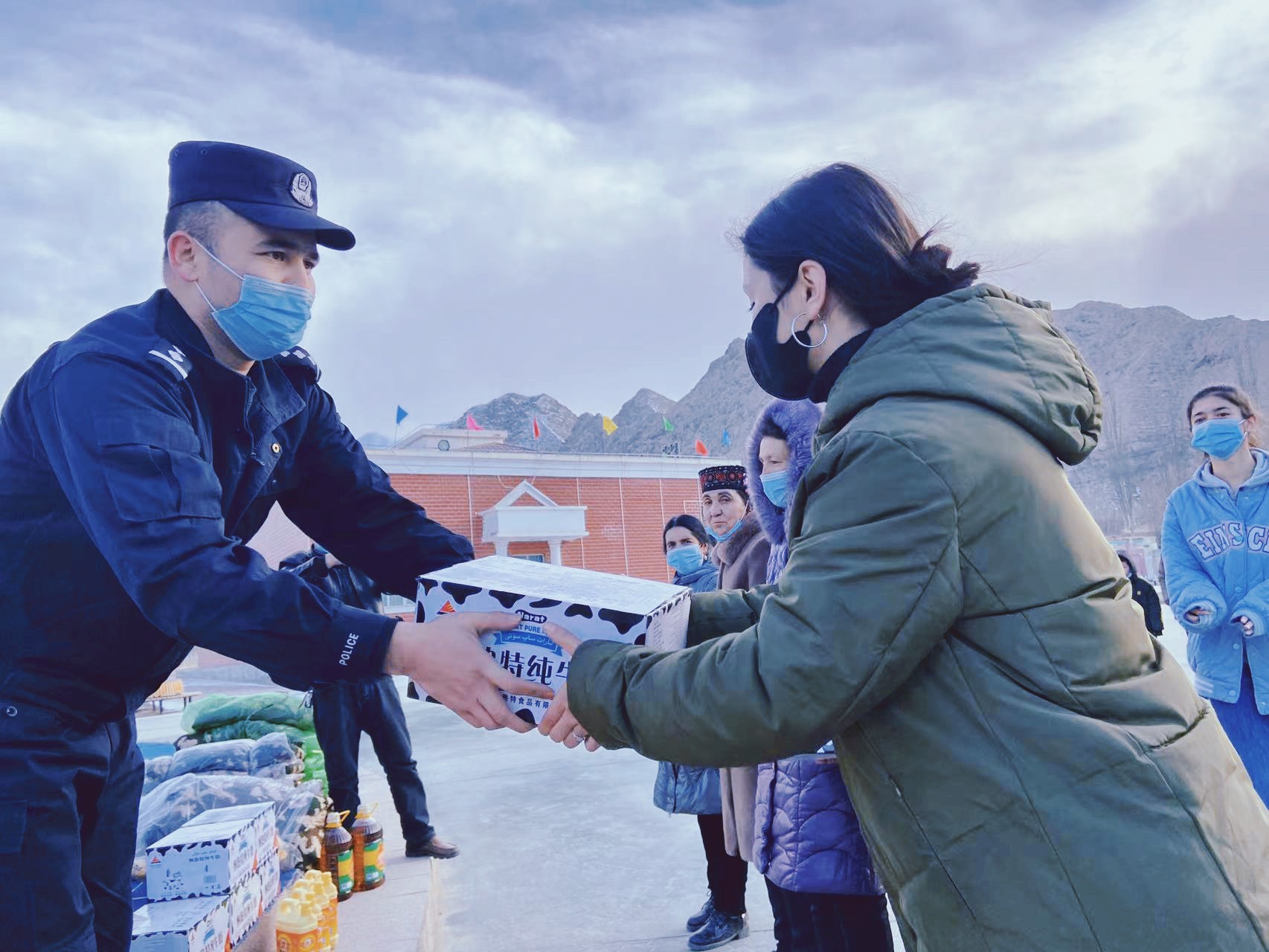 民警为老人分发牛奶等生活用品.jpg