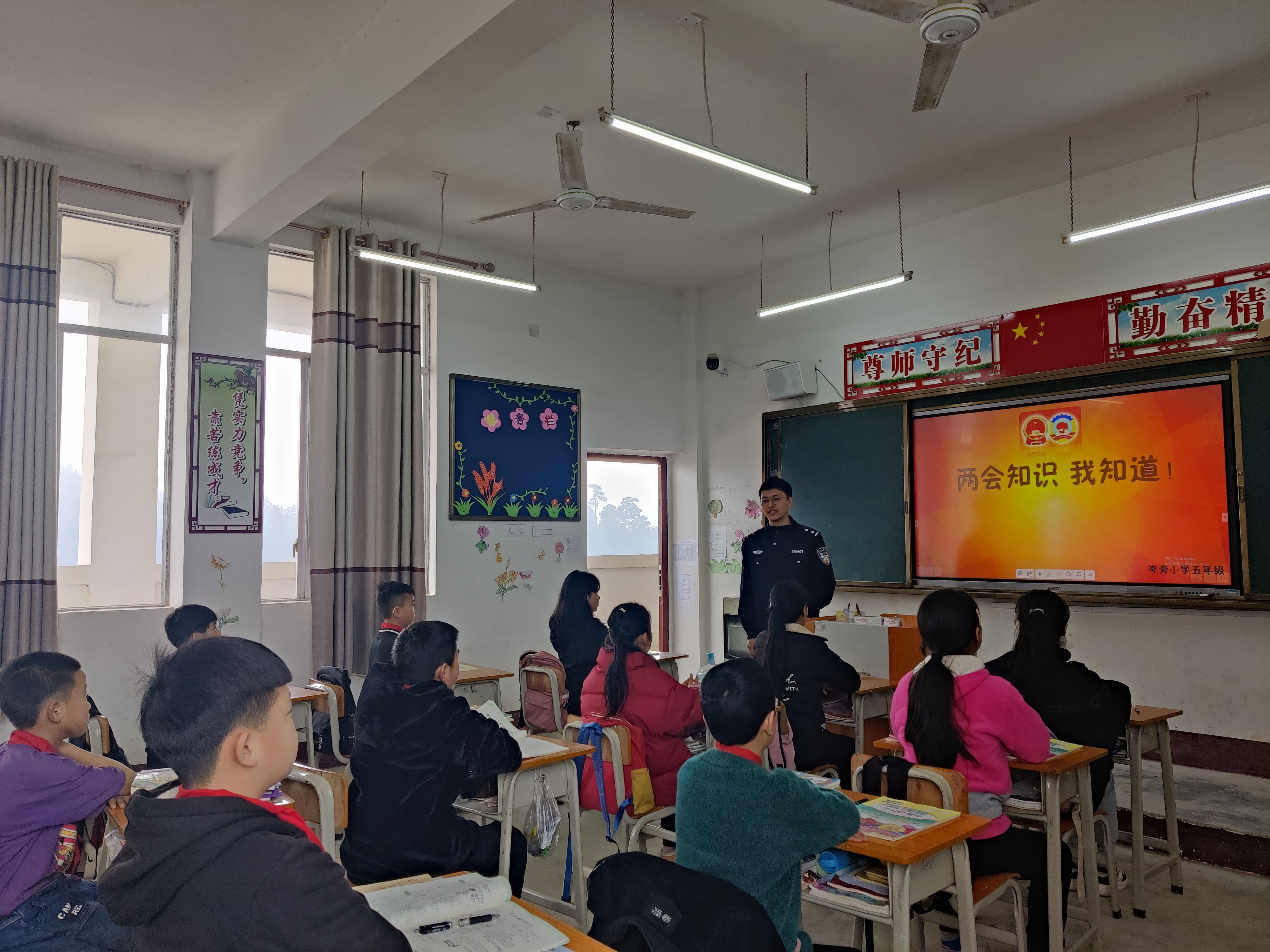 支教民警黄杰辉和学生一起学习两会知识.jpg