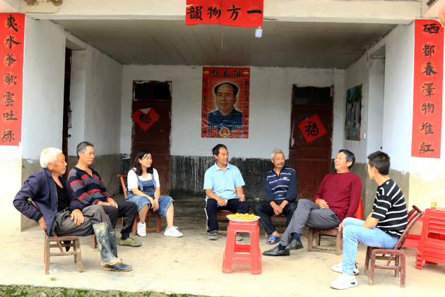 朱艳（左三）和村里的老党员围坐在一起商量下步发展。（通讯员 谭华 摄）.png