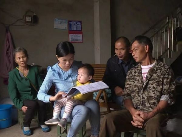 2018年11月李英媛抱着孩子入浦瓜村农作主户了解贫困户是否已享受应享受政策 拍摄者：硕龙出入境边防检查站供图.jpg