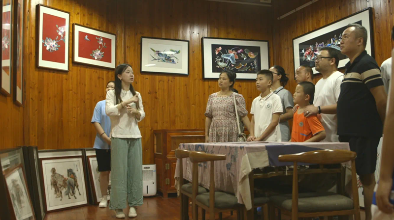 肖瑶正在向游客展示桃源刺绣技艺.png