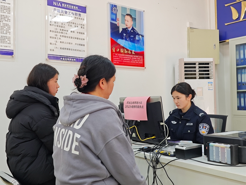 图为移民管理警察为群众办理边民证（潘正锦摄）.jpg