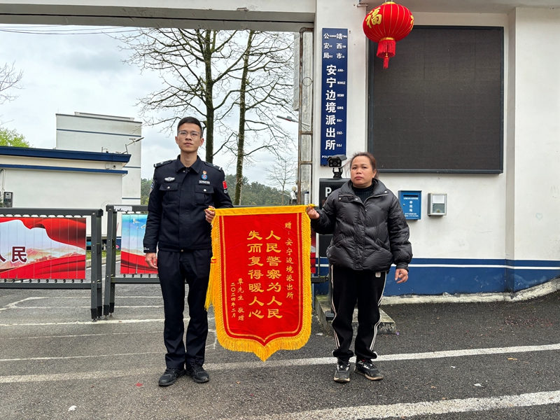 图为覃先生给民警送锦旗（黄小琴摄）.jpg