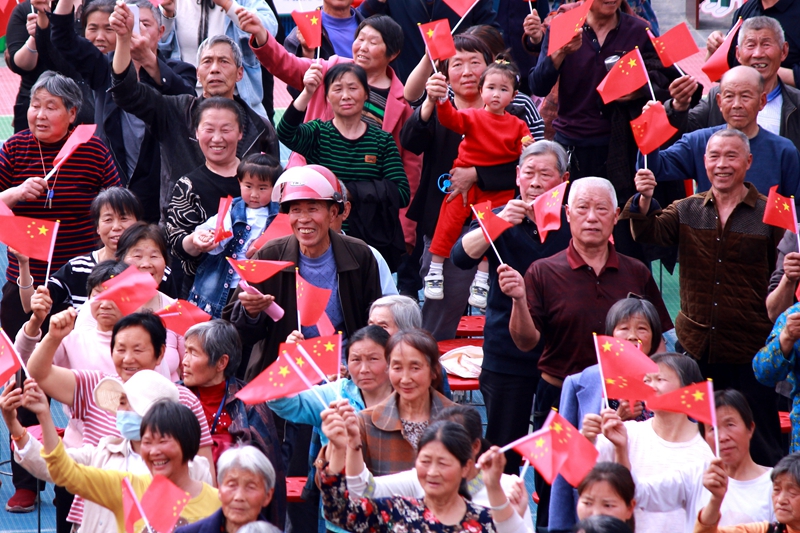 在十堰市郧阳区刘洞镇文明实践活动现场，群众挥舞国旗，爱国氛围热烈。.jpg