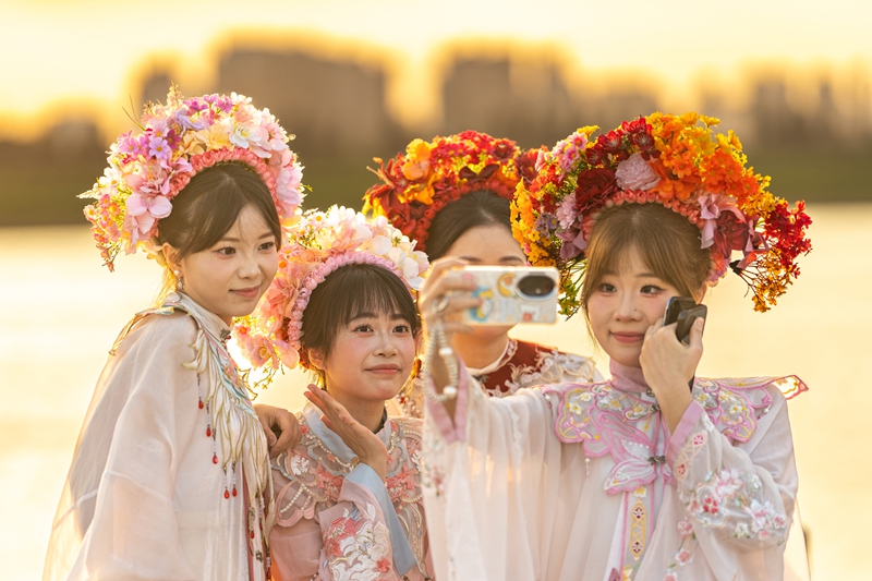 泉州丰泽蟳埔码头变身露天影棚，八方游客头戴簪花围，身着华服，在温柔暮色中定格簪花浪漫。（陈起拓 摄）.jpg