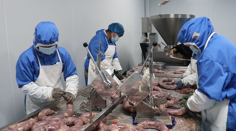 石梯子乡供销合作社食品厂加工厂房里，工人们正在灌制熏马肠.jpg