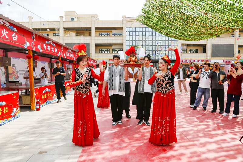 在六师五家渠市举办的第三届“郁”见美食餐饮大赛上，工作人员正在展示新鲜美味的烤骆驼。 魏新江 摄.jpg