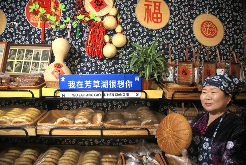 芳草湖个体商户魏花花锅盔店店主正在向客人展示锅盔。特约通讯员 魏新江摄.jpg