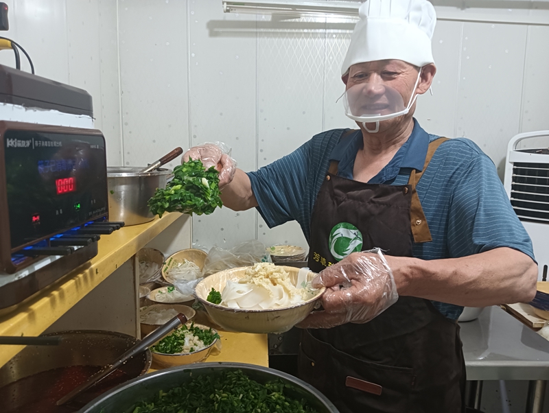芳草湖农场凉皮经营户韩国玉正在为顾客调制凉皮。 于三 摄.jpg