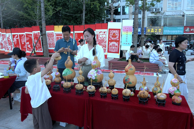 嵩县喷泉广场，小朋友在询问非遗作品 赵明辰摄.JPG