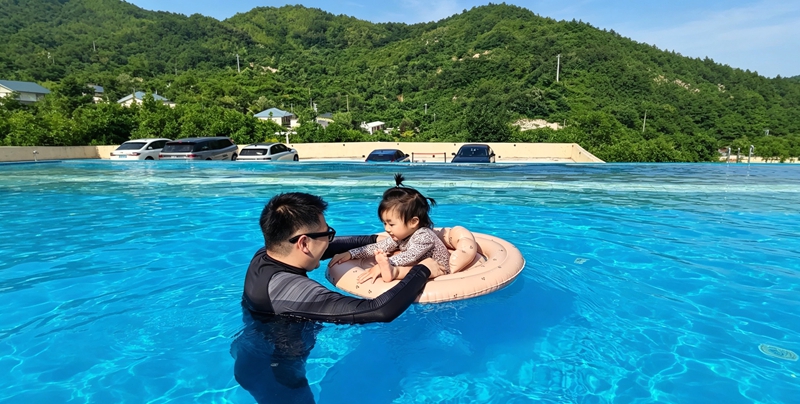 游客带着孩子在无边泳池戏水.jpg