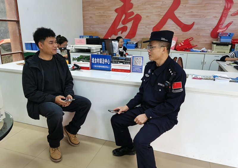 图为黄明忠向群众介绍户籍政策法规（蒋德校 摄）.jpg